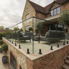 Black spigot glass balustrade system used on garden decking, providing safety without obstructing views