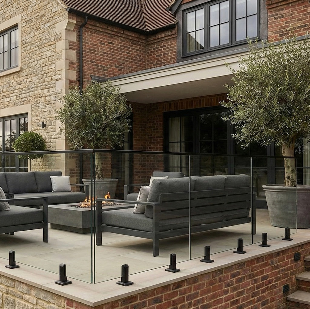 Black spigot and glass balustrade system installed on outdoor decking, featuring clear glass panels and modern minimalist design