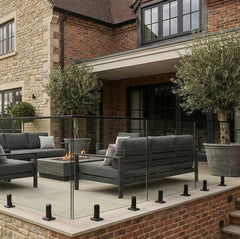 Black spigot and glass balustrade system installed on outdoor decking, featuring clear glass panels and modern minimalist design