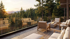 Outdoor patio with wooden furniture and a fire pit, surrounded by trees and mountains.
