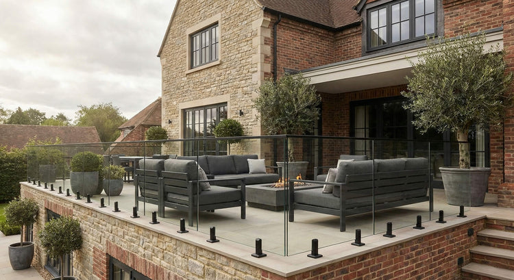 Outdoor patio area with furniture and fire pit in front of a brick house.
