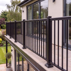 Black aluminium balustrade with vertical pickets fitted along the edge of a first-floor balcony on a modern UK home