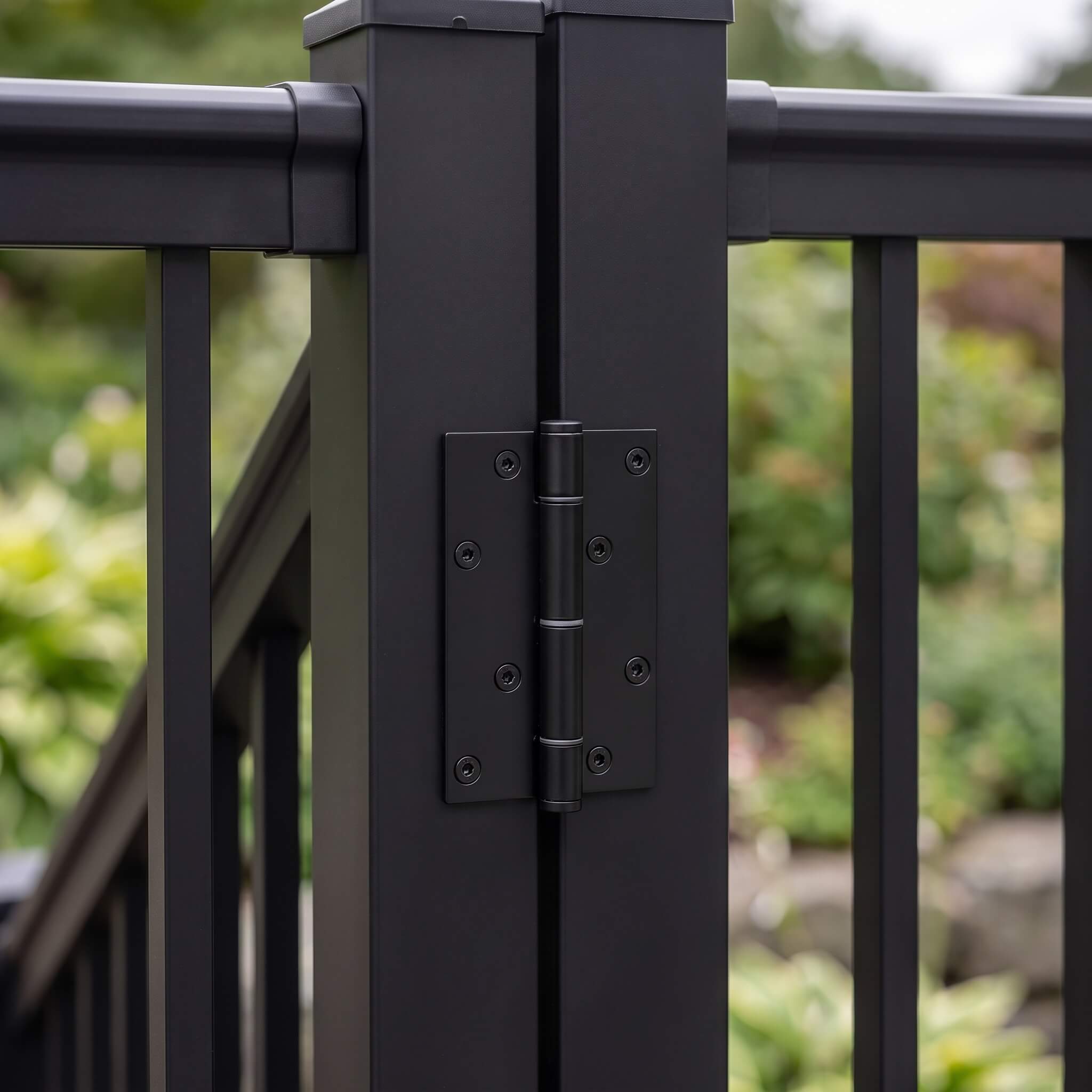 Black hinge hardware connecting the aluminium balustrade gate frame to the main post, matt powder-coated finish