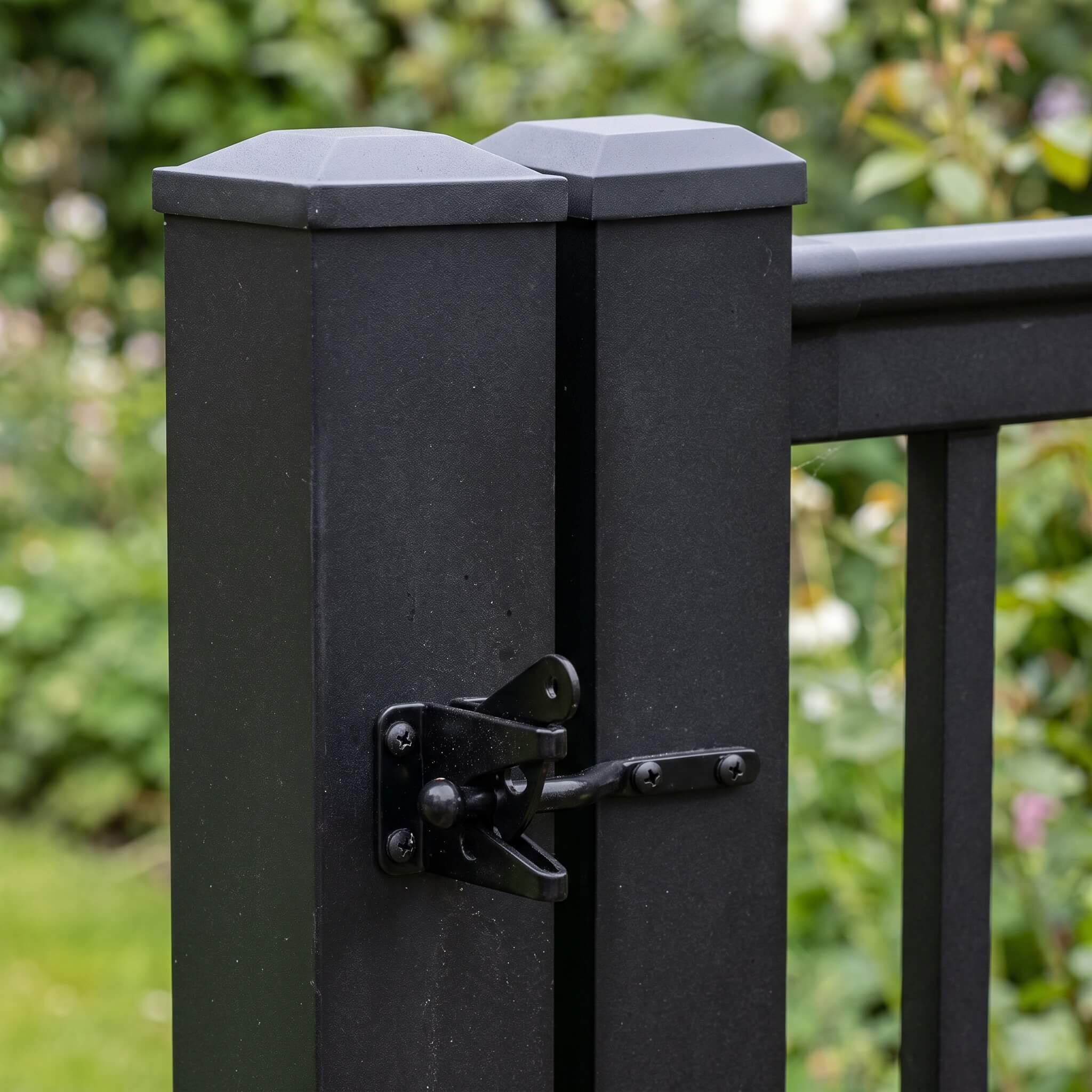 Spring-loaded black latch on the aluminium balustrade gate, mounted between the gate frame and main post