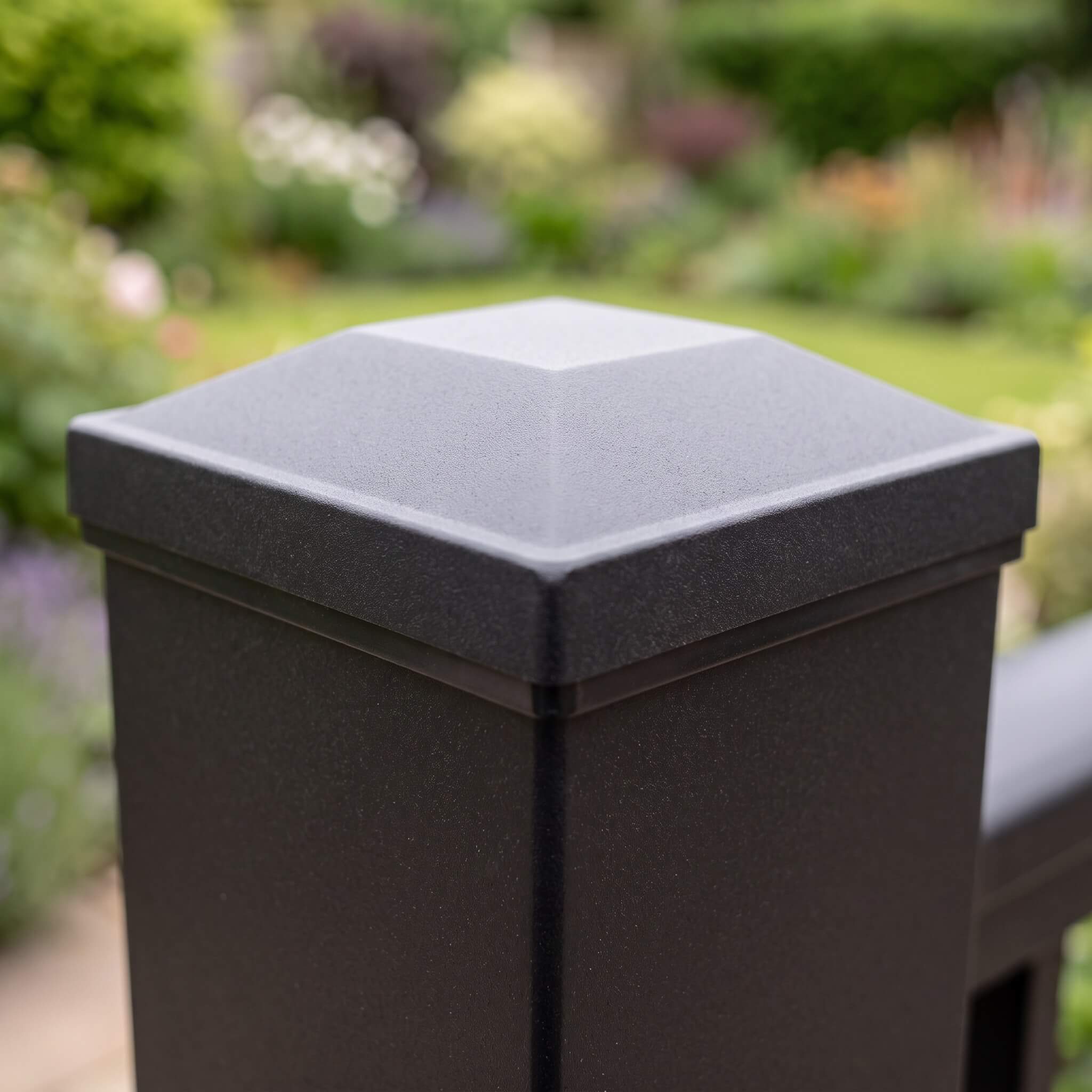 Close-up of the flat black post cap on a 75mm square aluminium balustrade post, matt powder-coated finish