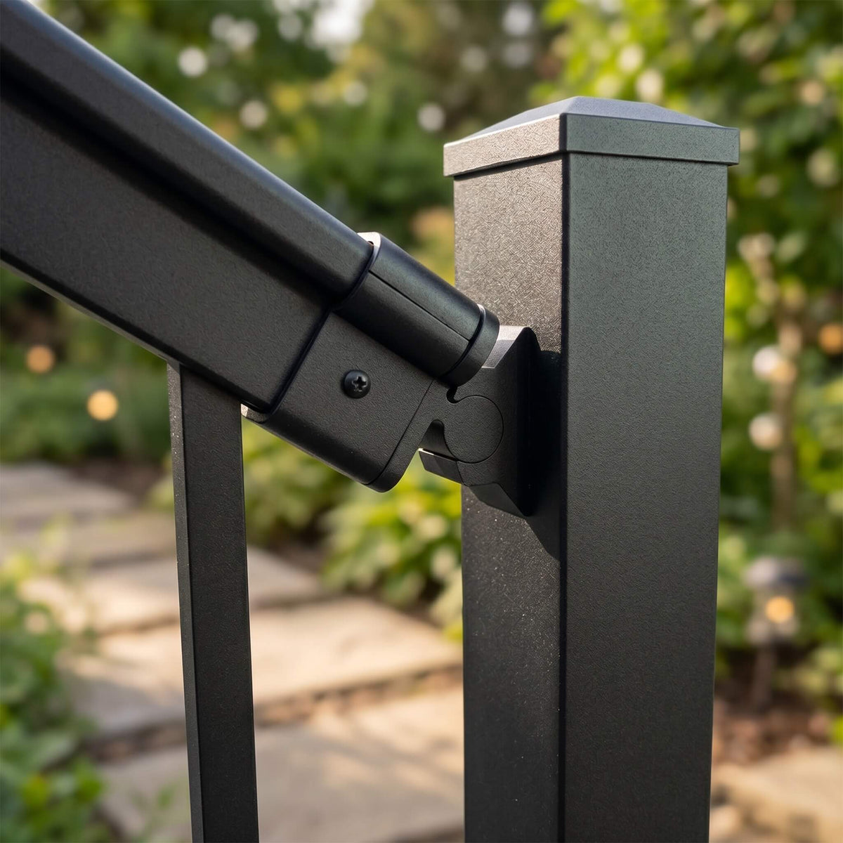 Close-up of a black aluminium stair bracket fixing the handrail to a balustrade post