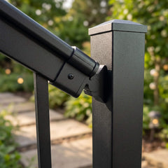 Close-up of a black aluminium stair bracket fixing the handrail to a balustrade post