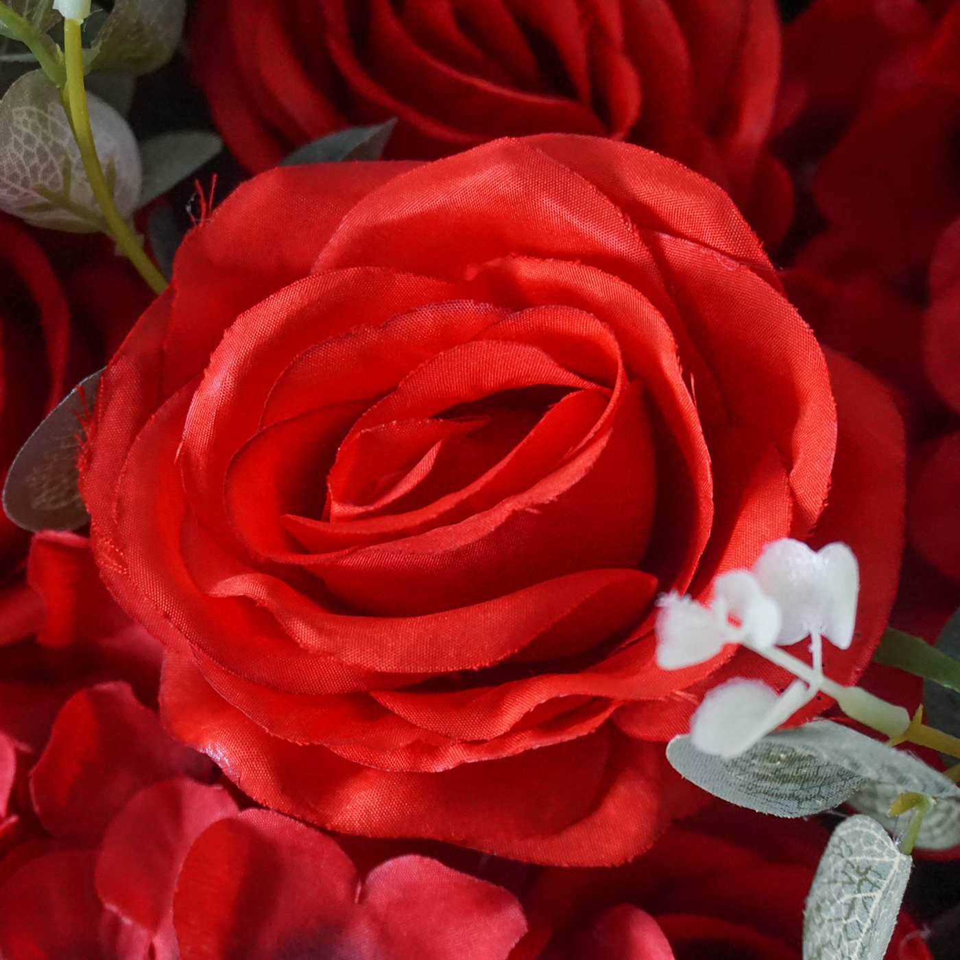 close up of artificial red rose and eucalyptus spray