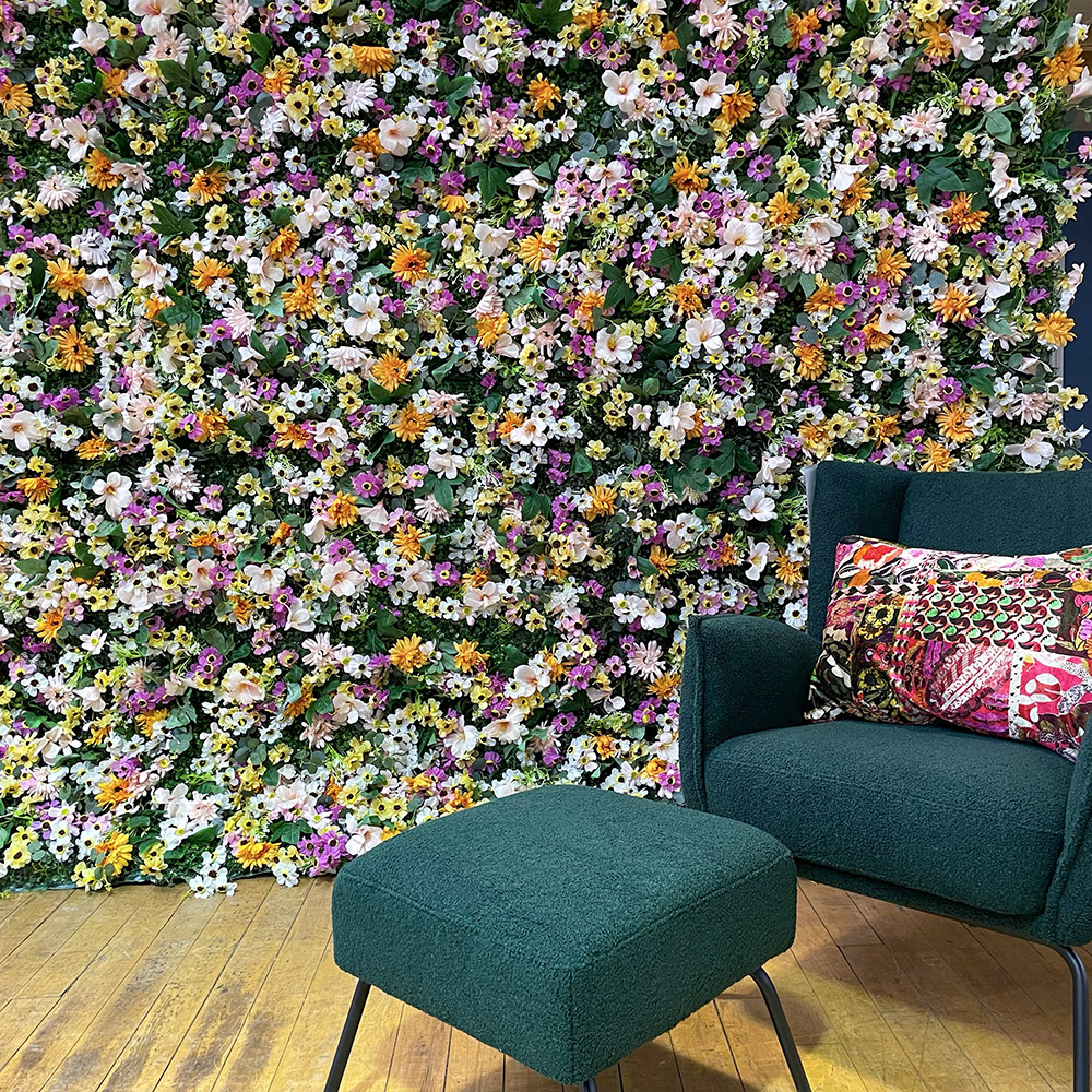 The gorgeous colourful Ditsy Daisy flower wall backdrop set up in a show room for an event