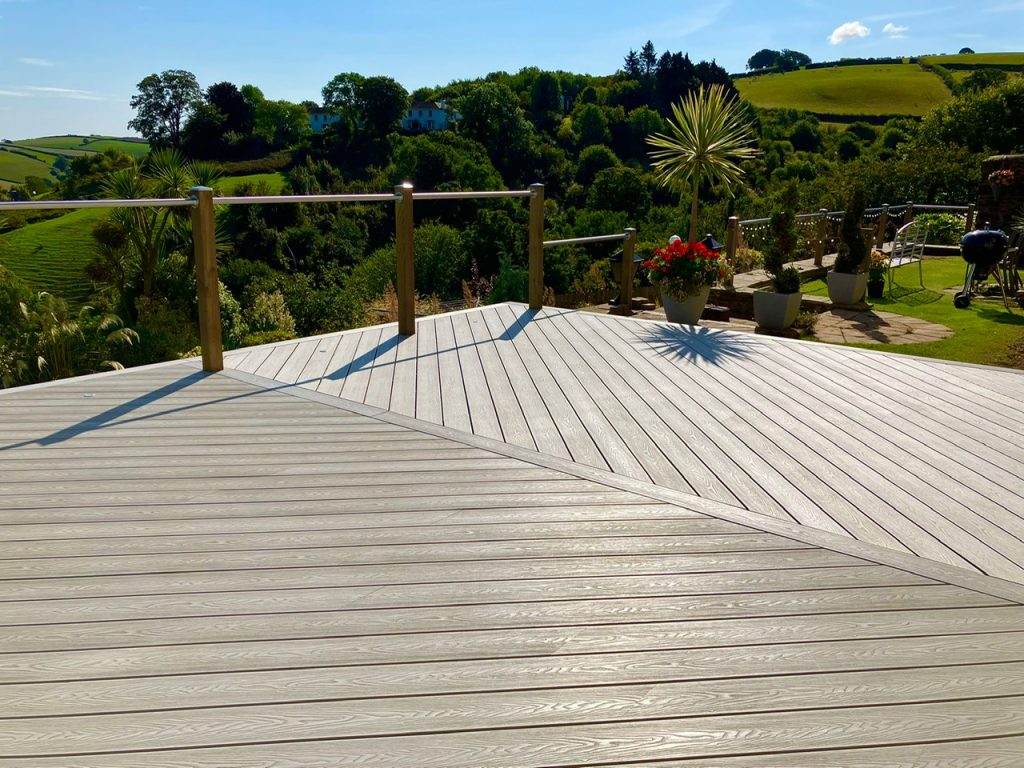 Aged Oak composite decking boards laid in a herringbone design and cleaned using a power washer
