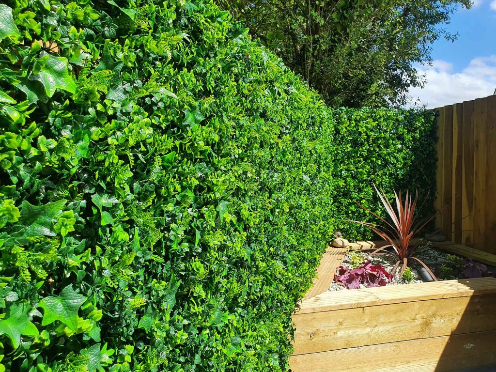 artificial amazon foliage panels used to cover a wooden fence in a UK garden