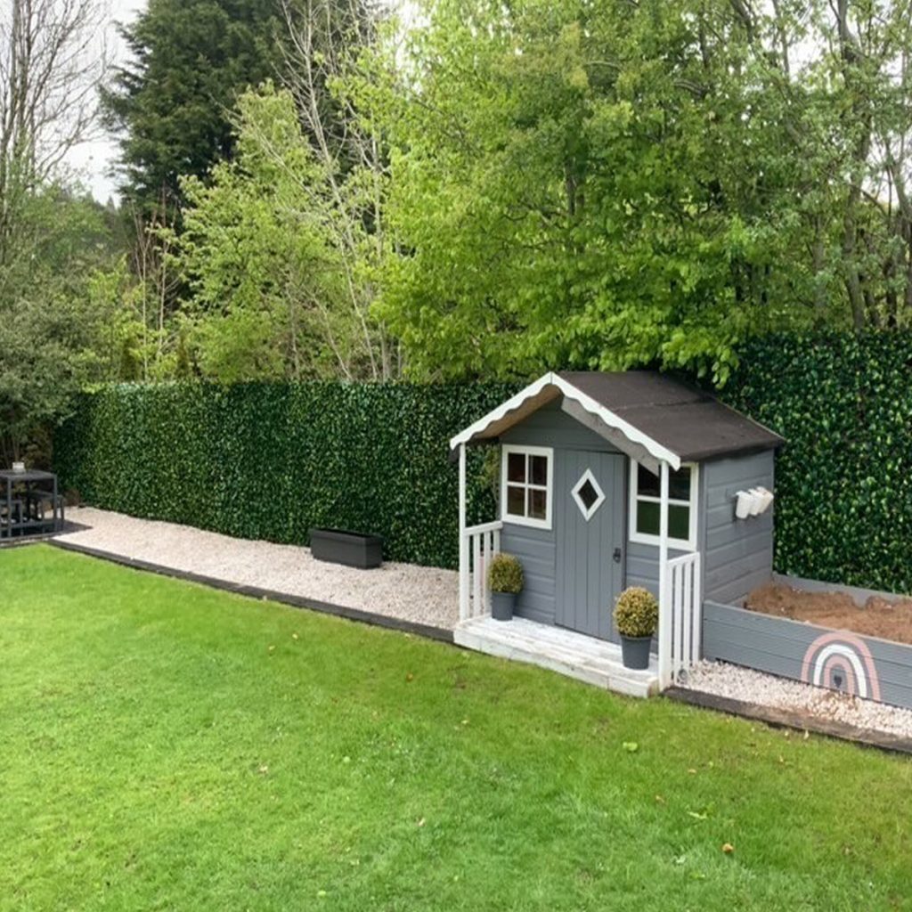 extendable hedge screening plants attached to a wooden fence