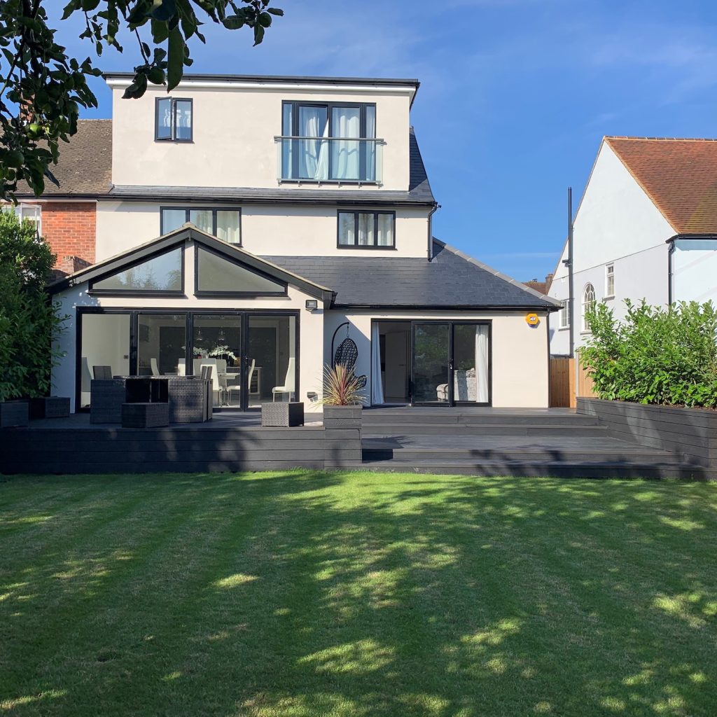 black composite decking in a large garden creating a raised outdoor living platform